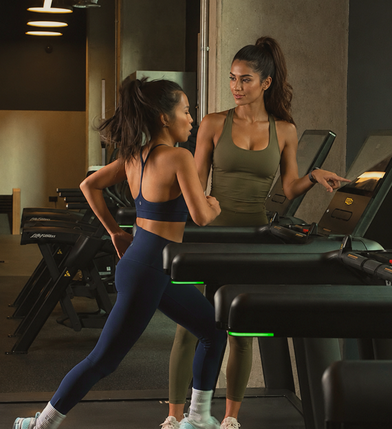 Coach guiding a client through a training session in a modern gym